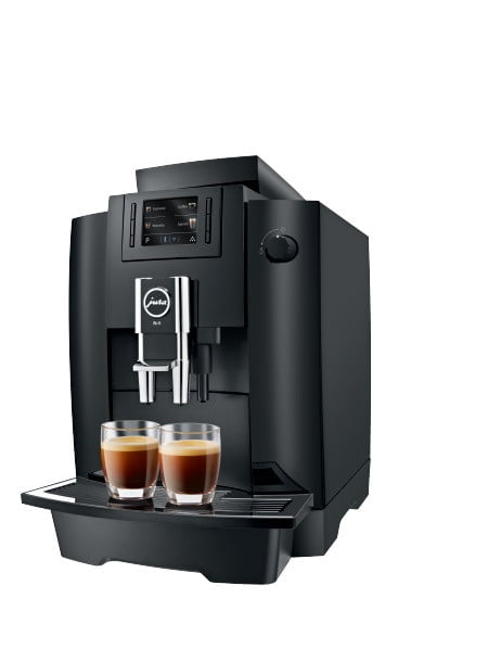 Kaffemaskine fra producenten JURA i versionen WE6, der fremstår i farven sort og med to nybryggede kopper kaffer
