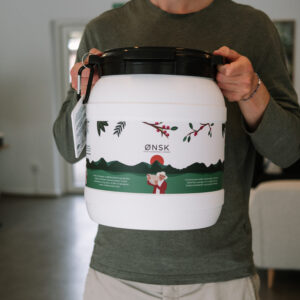 Ziggy fra ØNSK holder en kaffetønde til opbevaring af økologisk kaffe fra ØNSK